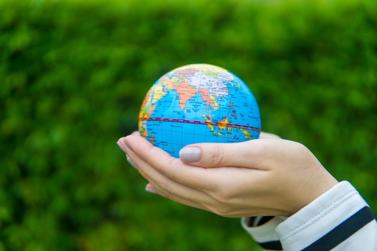 Globe highlighting Africa beside notebooks and learning materials